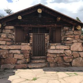 The front of the Halfway House, a stone building with large wooden beams poking out along the roof line.