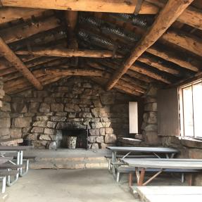 Inside the Halfway House with stone walls and large wooden beams on the ceiling.