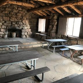 Inside the Halfway House there are six picnic tables and a stone platform at the back with a non-operational fireplace. 