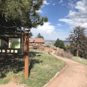 A gravel path leads to the Halfway House patio with peekaboo views of Boulder beyond.