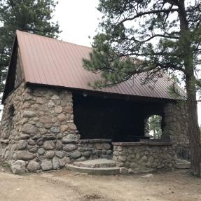 The Stone Shelter, a stone building with an open front, two side windows and a metal roof.