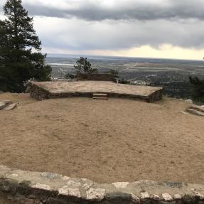 The Sunrise Amphitheater stone stage is visible across the center circle from the first row of stone seats.