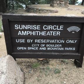 The sign states: Sunrise Circle Amphitheater, use by reservation only, City of Boulder Open Space and Mountain Parks.