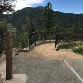 The dirt ramp down to the Sunrise Amphitheater starts from the paved parking area.