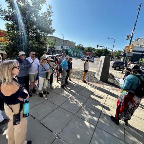 Participants of a public art tour listening to the guide