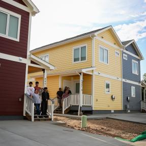 Families pose for a picture in front of their new BoulderMOD homes. 