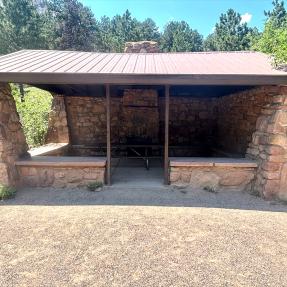 A close-up view of the front of the open-air, stone Bluebell Shelter.