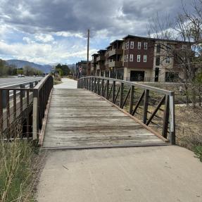 wooden deck bridge to concrete path