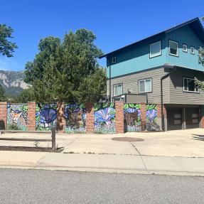 Colorful mural of bears and flowers on a public facing fence