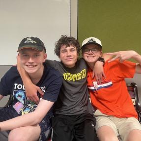 Three children posing and smiling for a photo.